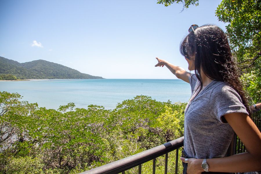 Girl pointing at the seascape at the daintree rainforest