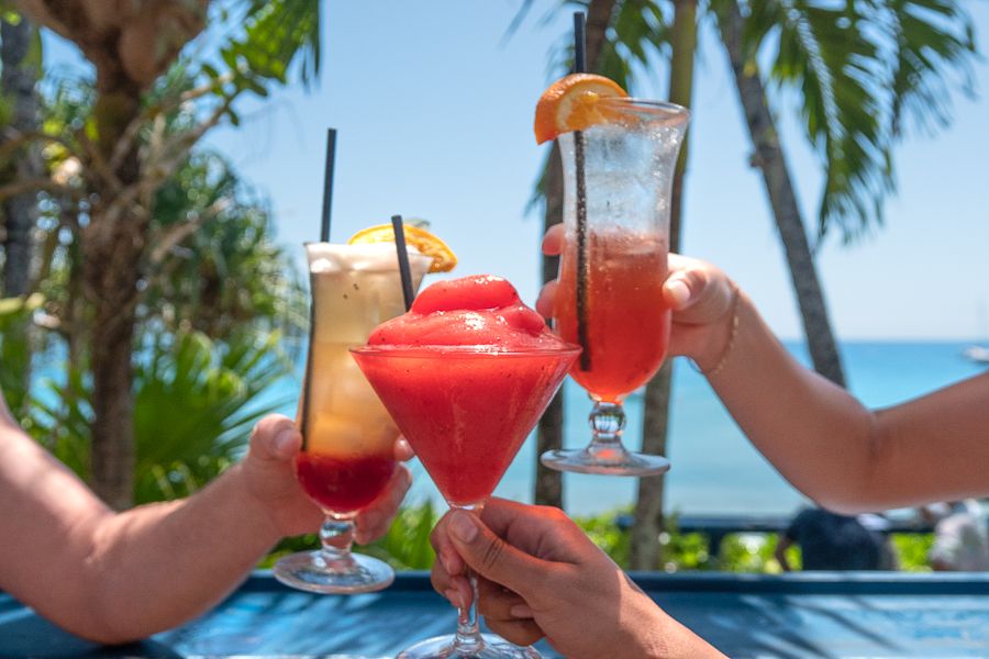 Three fruity cocktails in front of the Coral Sea