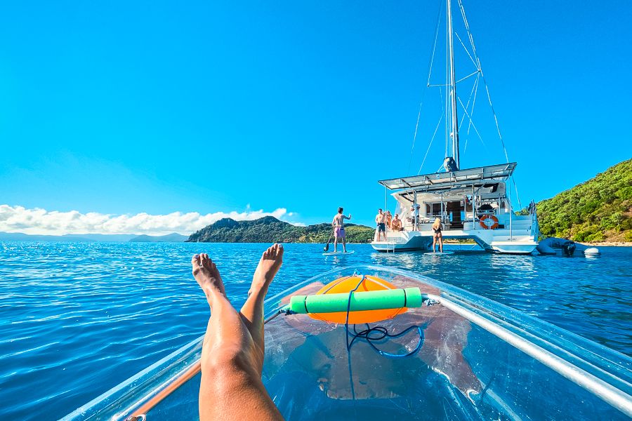 girl kayaking in front of a catamaran in the whitsundays