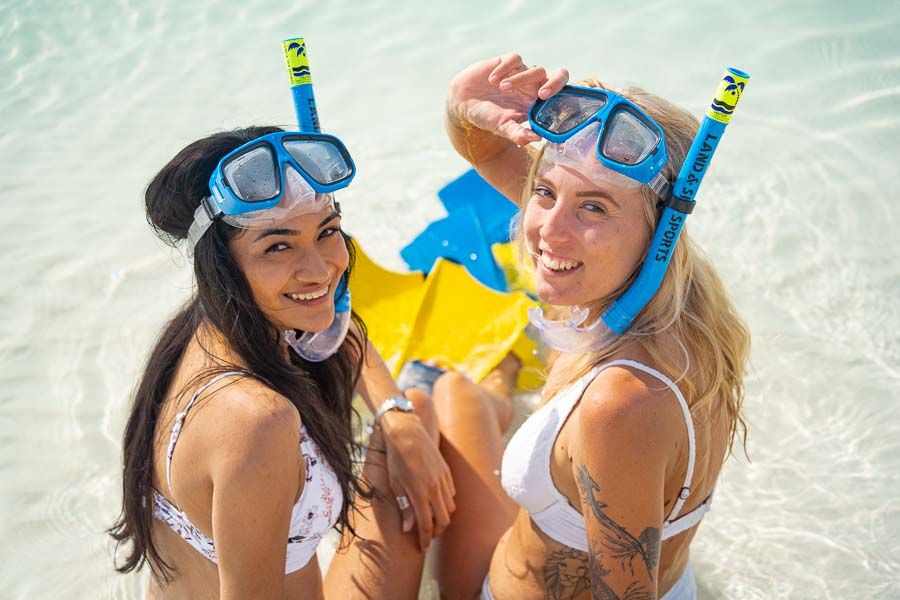 two girls with snorkel gear on a beach in the Whitsundays