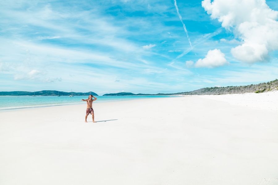 man walking on white sand on beach