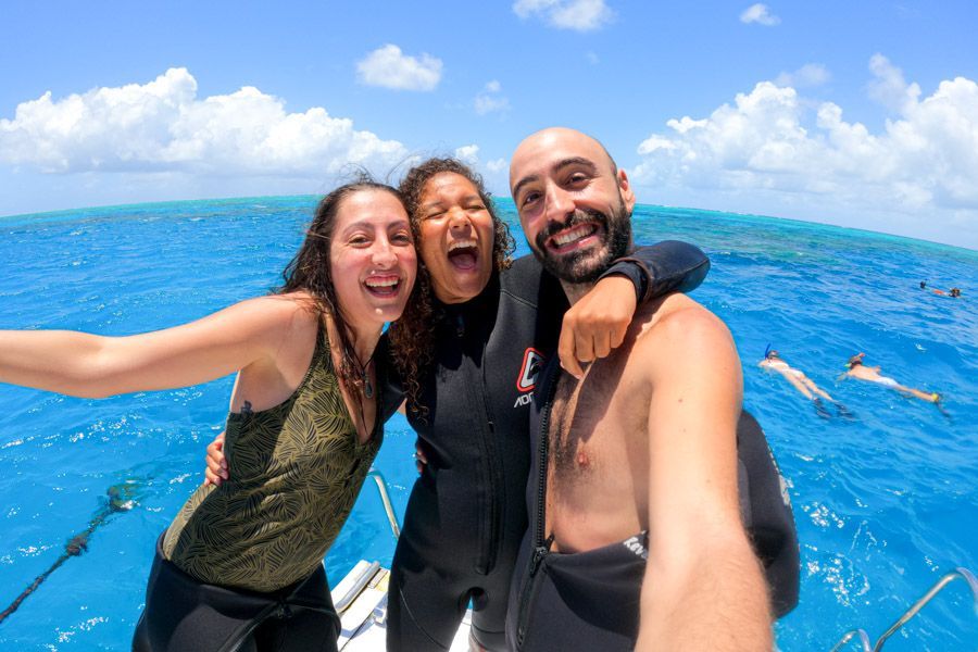 travellers smiling on a boat tour on the reef near cairns