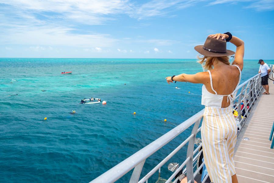 Traveller pointing at the Great Barrier Reef from the Reefworld pontoon