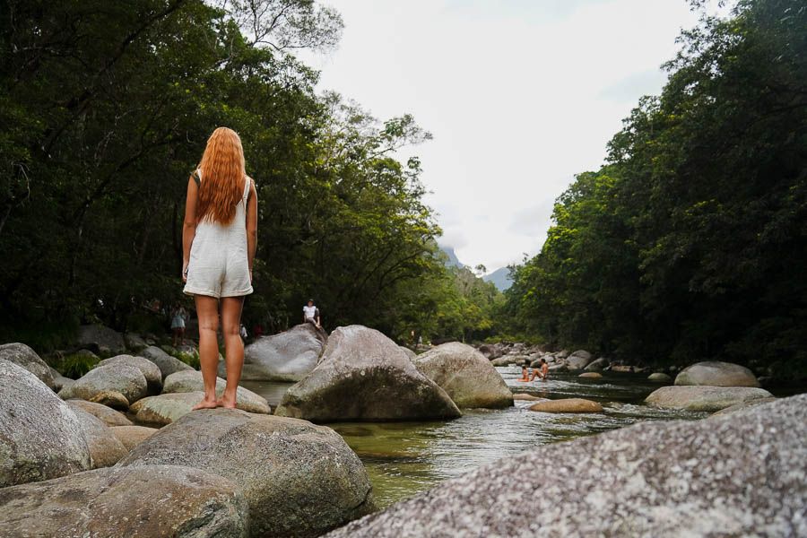 girl standing next to a river at Mossman Gorge