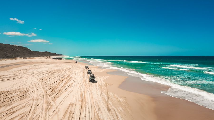 Three 4WDs on the golden sands of K'gari