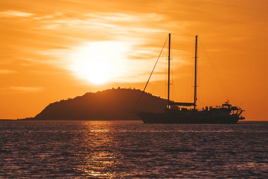 Luxury catamaran silhouetted by sunset