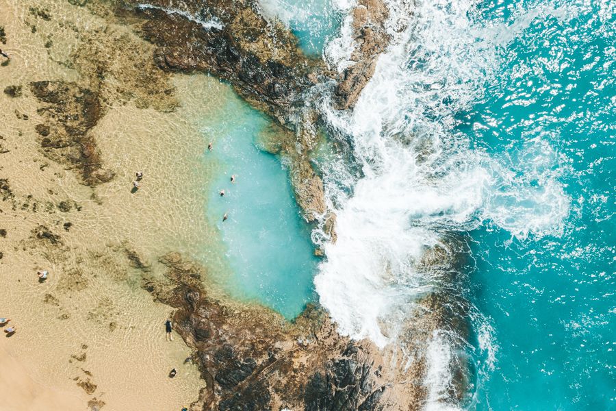 aerial view of bright blue rock pools on the k'gari coast