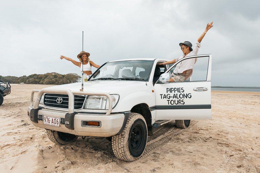 girls in a white 4wd on a driving tour of k'gari