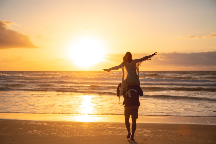 couple frolicking on the beach at sunrise on k'gari