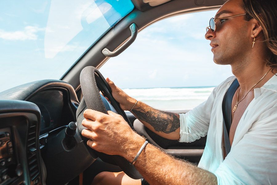 man driving a 4wd vehicle on K'gari's beach