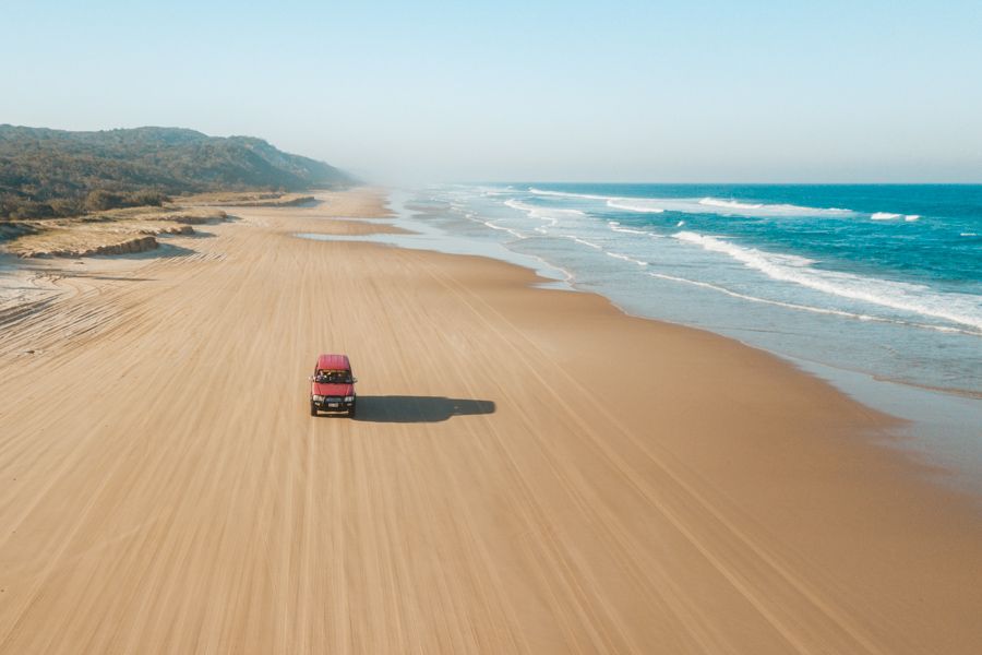 car driving on the golden sand of 75 mile beach