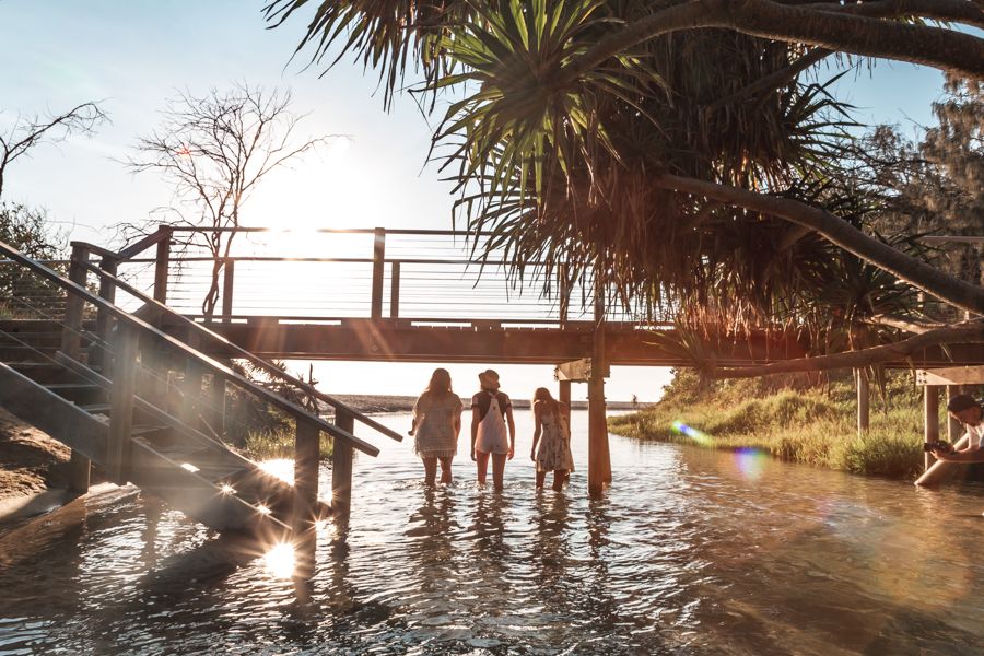 people in creek at sunrise