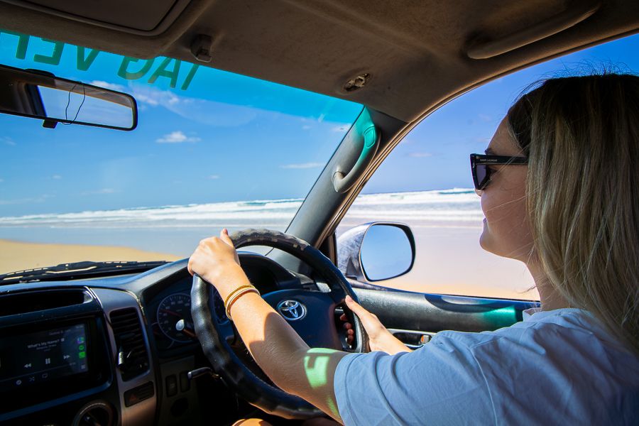 girl driving in a 4wd vehicle on kgari sandy beach