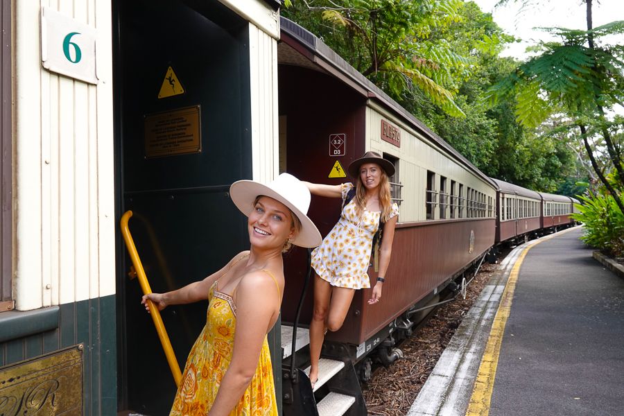 Two girls hanging off a Kuranda Scenic Railway train