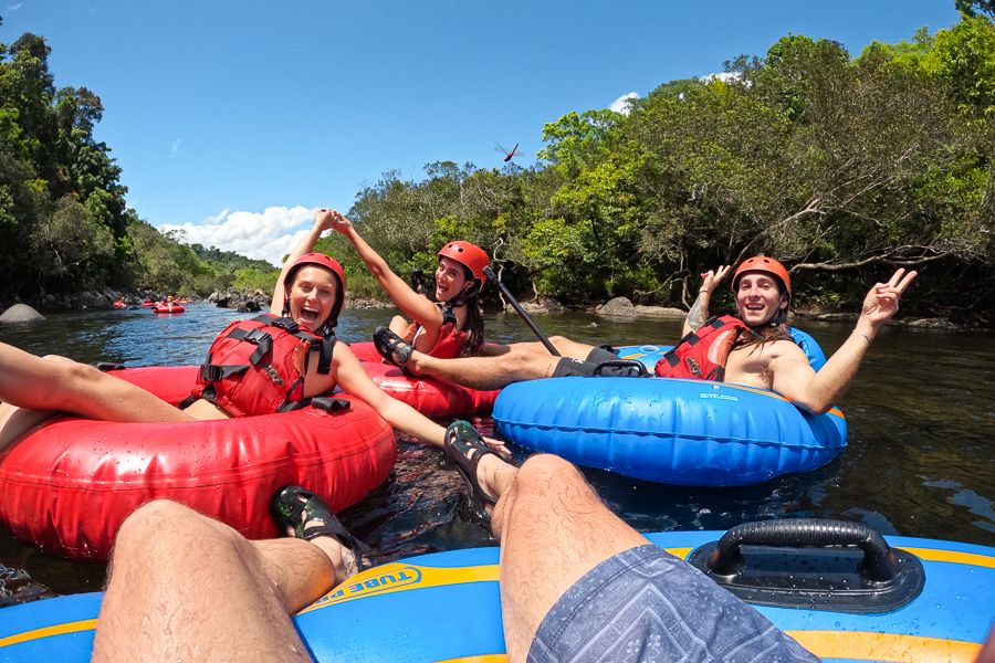 travellers rafting down a tropical river in the rainforest near cairns