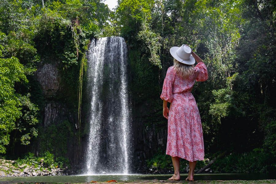 girl standing in front of millaa millaa fals near cairns