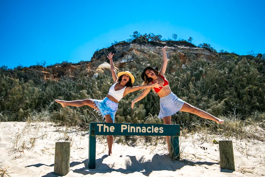 girls posing near sign