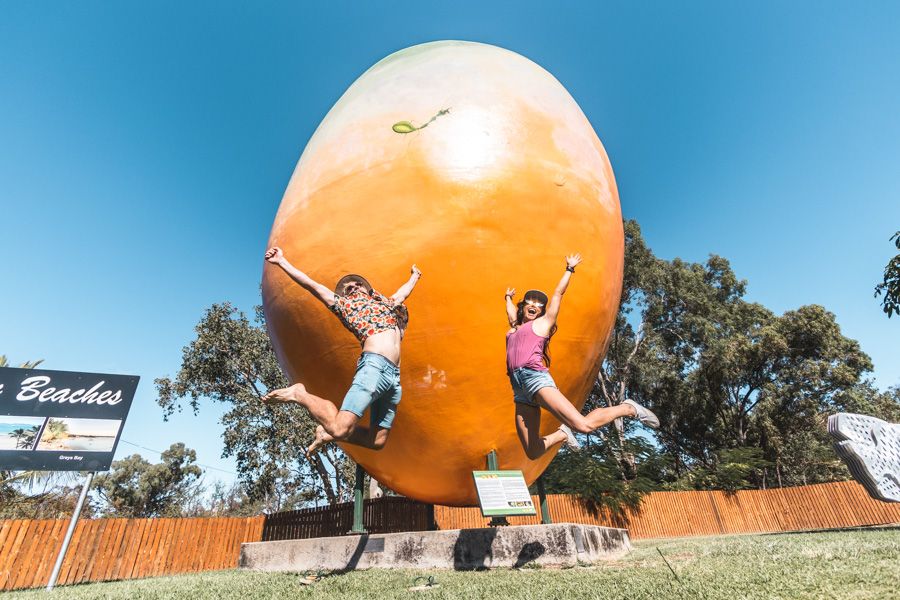 two people jumping in front of the Bowen Big Mango