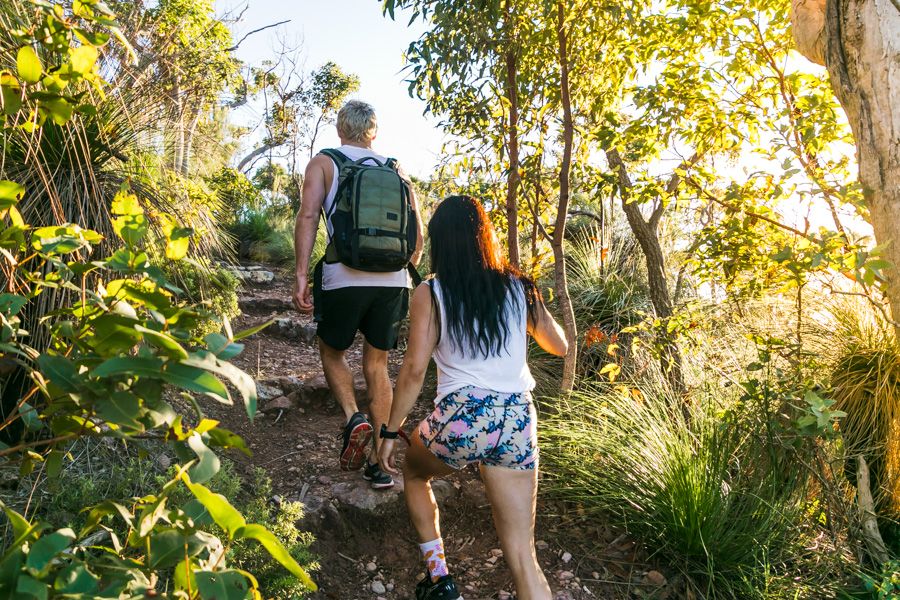 Two people with backpacks on hiking up a mountain