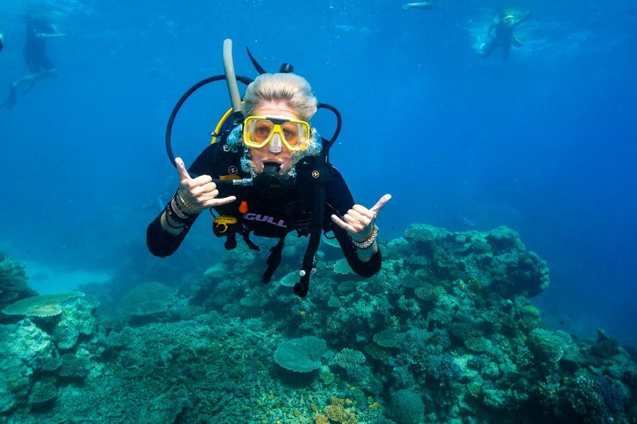 A girl with blonde hair underwater scuba diving