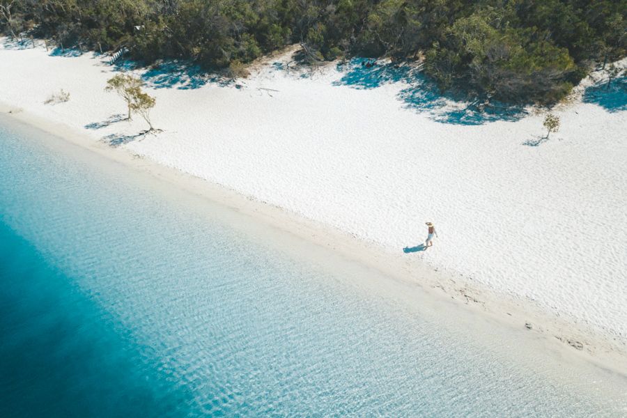 person walking near the white sand on Lake McKenzie