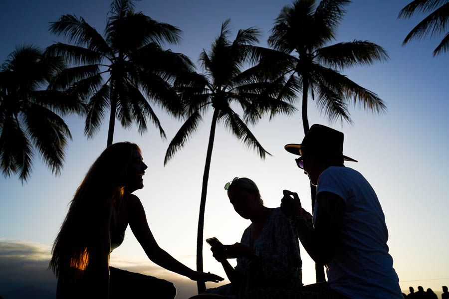 Three people silhouetted by sun, having fun