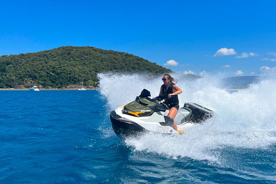 A girl on a jetski with the whitewash behind her