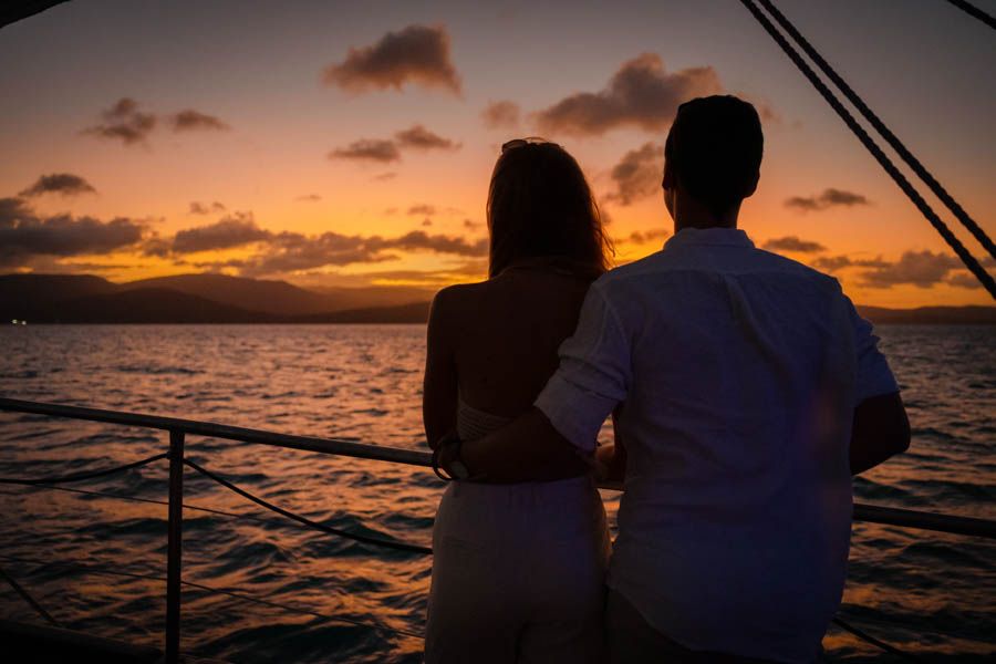 A couple looking out at the sunset on a yacht