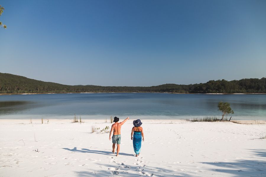 couple walking by Lake Mckenzie and pointing up