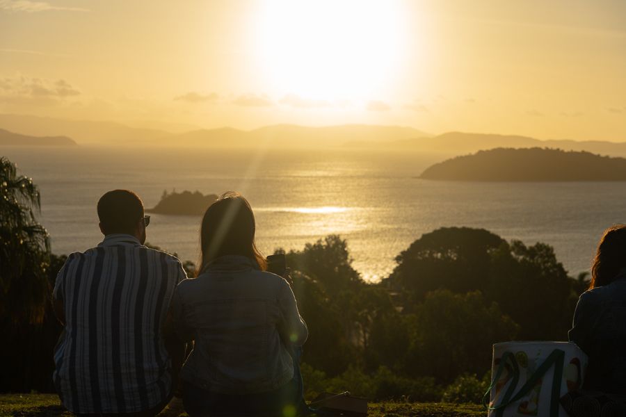 Two people with their backs to the camera and the sunset behind them