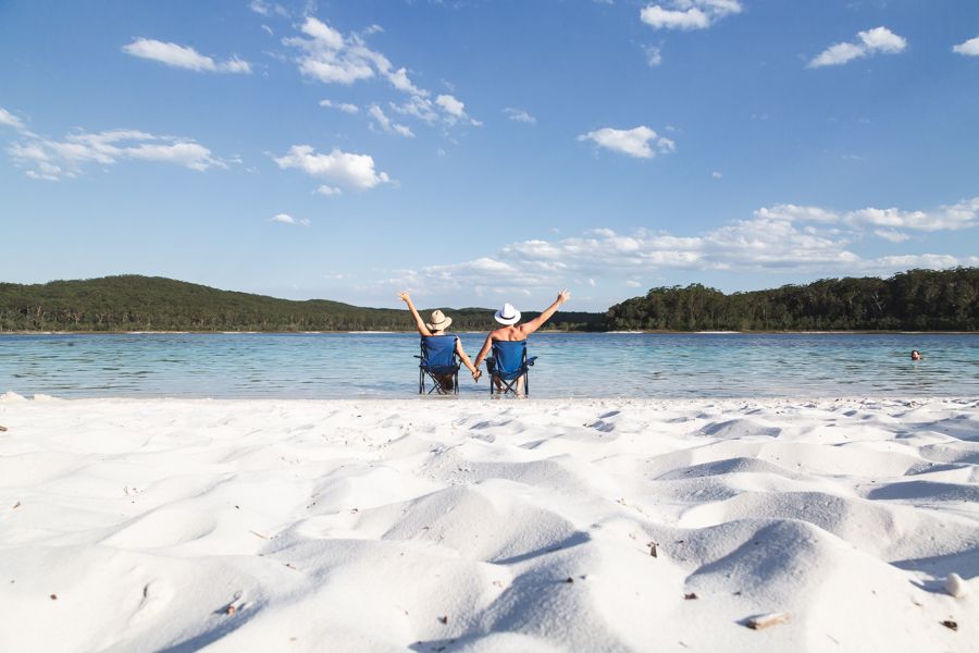 couple sitting in chairs and holding hands near Lake McKenzie