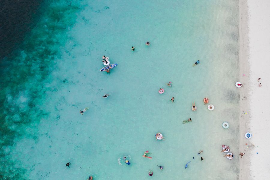 people in floats in the blue water of Lake McKenzie