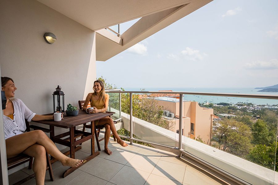 Two women on a balcony with an ocean view