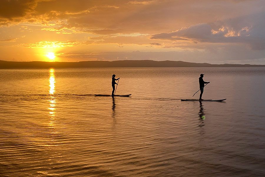 people paddleboarding in Noosa at sunrise