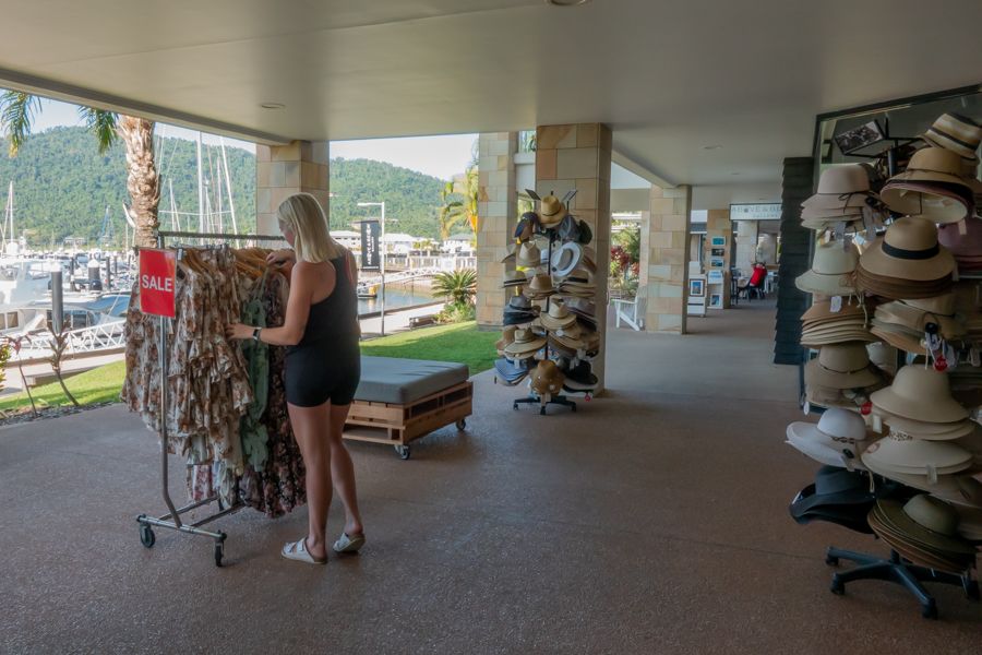 A woman looking through a rack on clothes on the foreshore