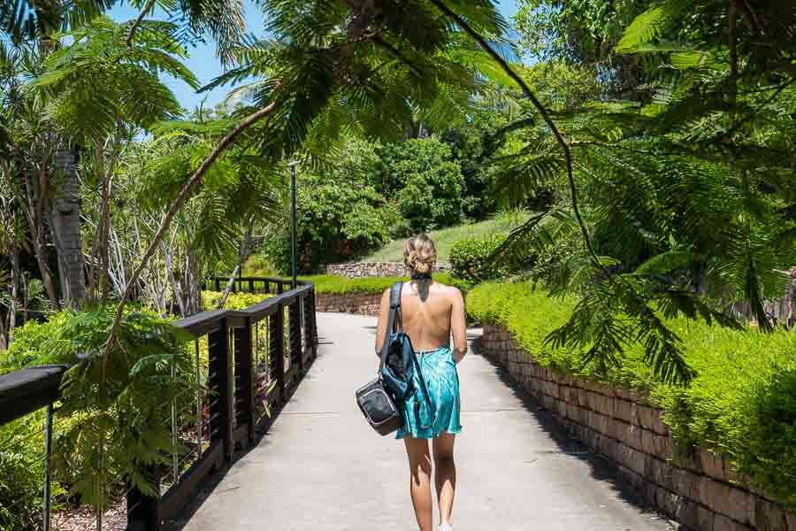 A woman in a bathing suit walking through a bardwalked forest