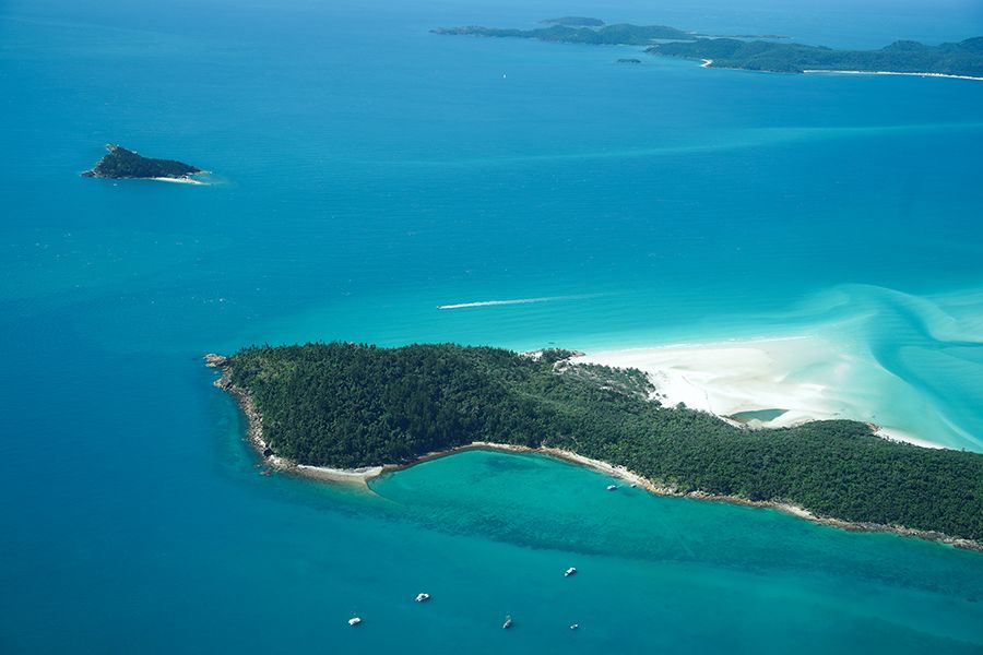 GSL seaplane overview of a small island with forest, sand and bright blue water