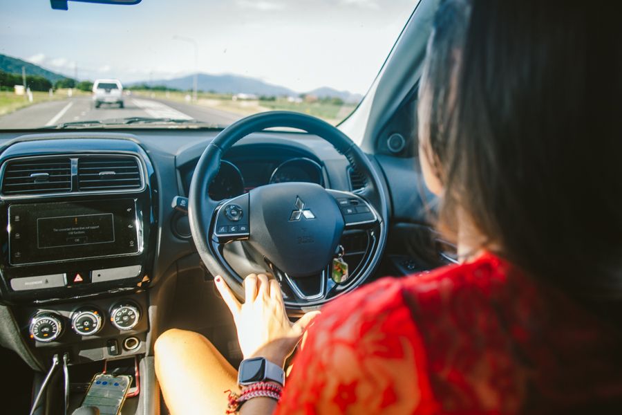 A woman in the drivers seat of a car