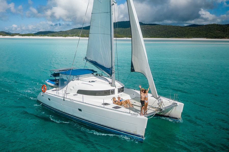 A group of people on a white catamaran in the Whitsunday Islands