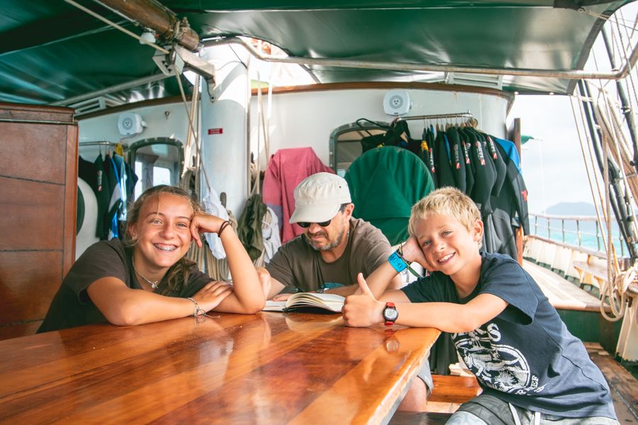 kids smiling around a table on a sailboat in the whitsundays