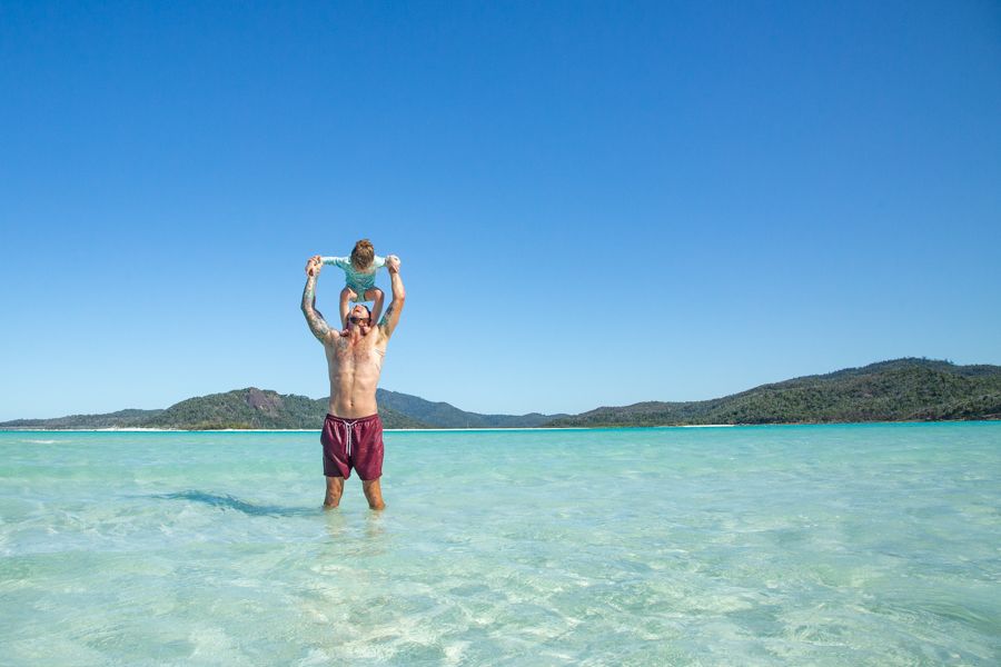 A man with his daughter in the blue waters of Whitsundays