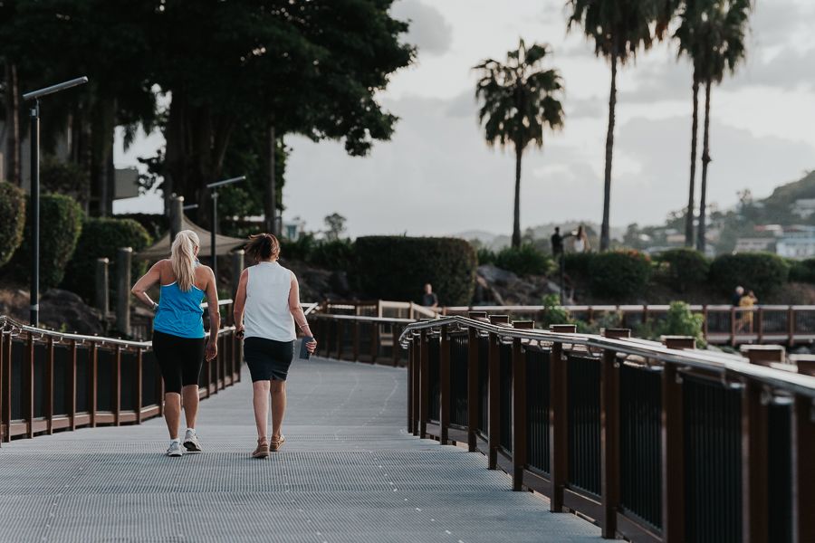 Two women walking along a boardwalk 