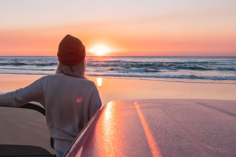 girl looking at the sunrise over the ocean on K"gari