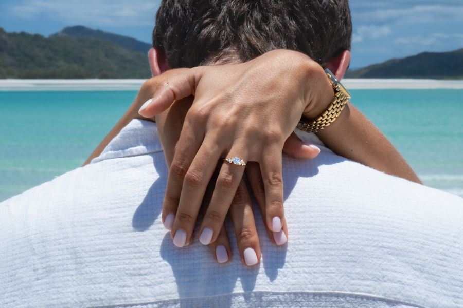 couple showing off engagement ring at whitehaven beach