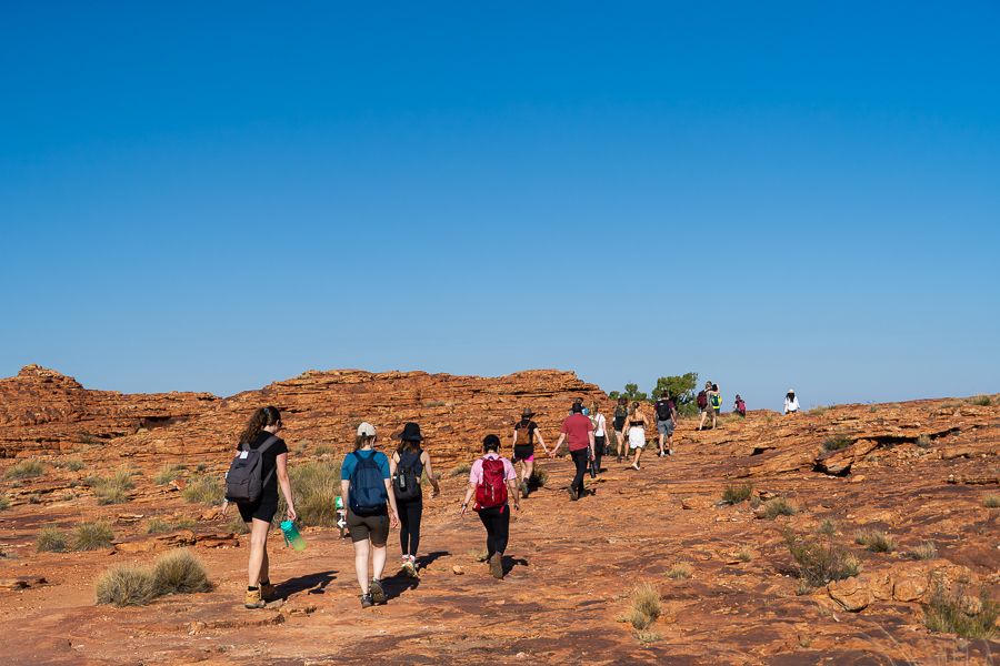 group of travellers walking over rocks in the outback