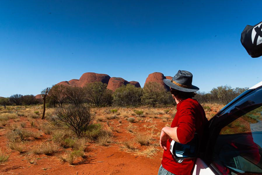 man leaning against a van looking at outback scenery