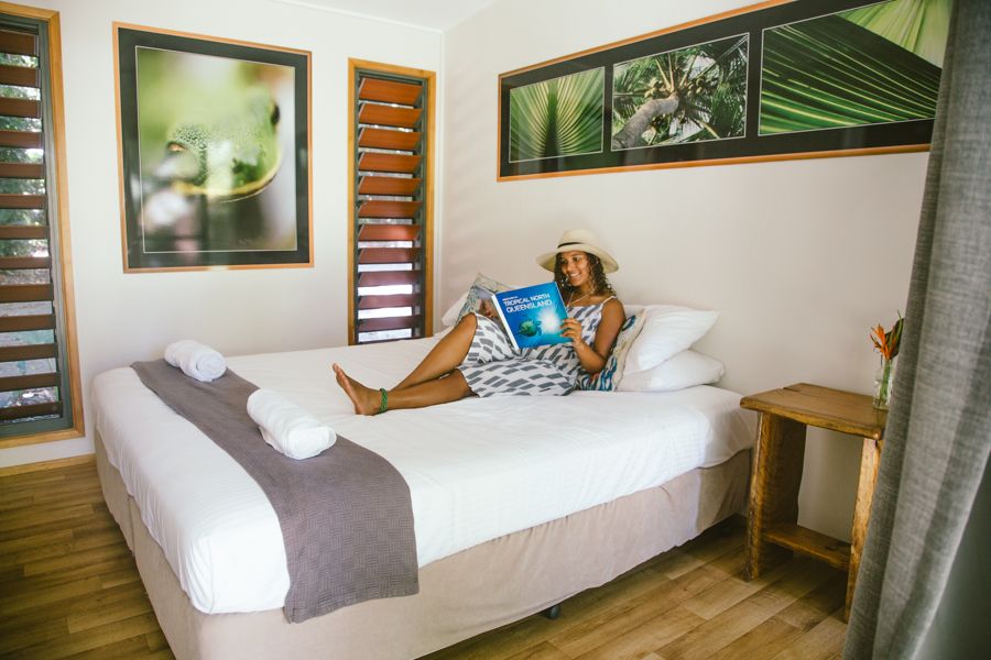 girl reading in a hotel bed in tropical north queensland