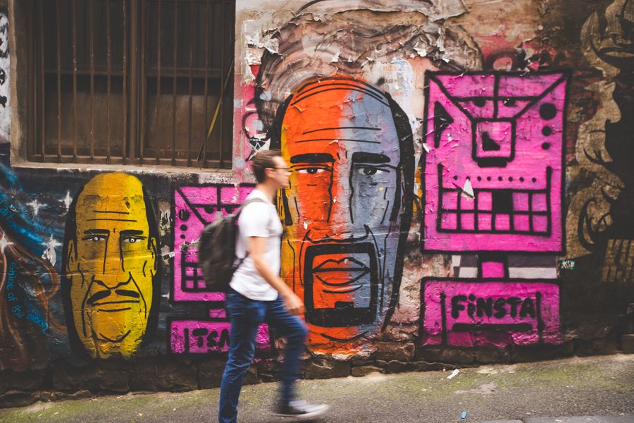 person walking past street art in melbourne