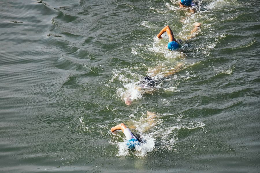 people swimming in the ocean in a triathlon race
