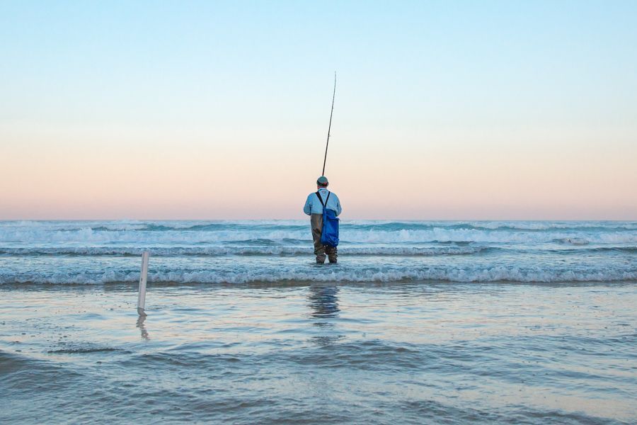 man fishing off the coast of kgari fraser island